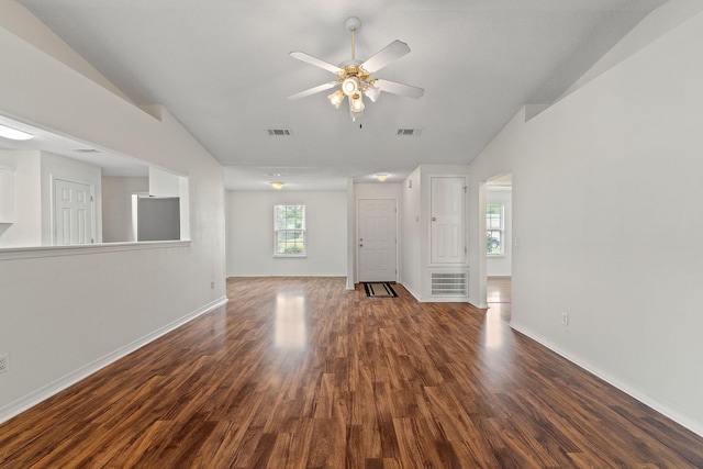 unfurnished living room featuring baseboards, wood finished floors, a wealth of natural light, and ceiling fan