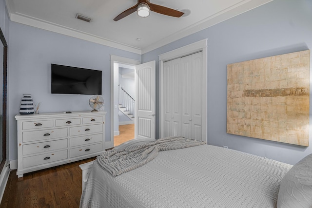 bedroom with a closet, ceiling fan, dark wood-style flooring, visible vents, and crown molding