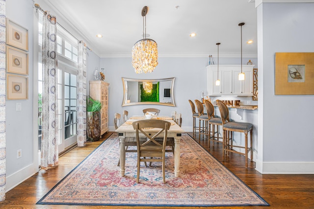 dining area with an inviting chandelier, wood finished floors, crown molding, and baseboards