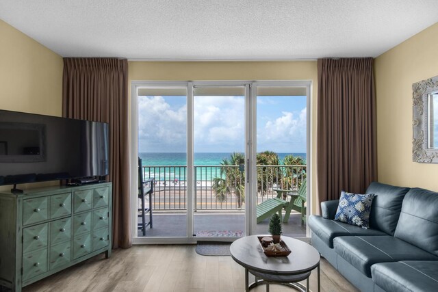 1160 Scenic Gulf Dr Unit 204A, Miramar Beach, FL 32550 - living room with a textured ceiling, a water view, and light wood-style flooring