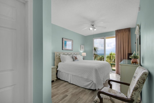 1160 Scenic Gulf Dr Unit 204A, Miramar Beach, FL 32550 - bedroom with a textured ceiling, ceiling fan, light wood-style flooring, and access to exterior