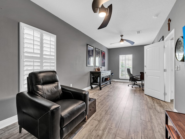 home office featuring wood finished floors, visible vents, a ceiling fan, and baseboards