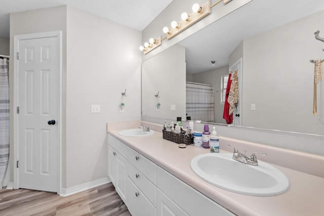 1207 Jefferyscot Dr, Crestview, FL 32536 - full bathroom featuring baseboards, wood finished floors, double vanity, and a sink