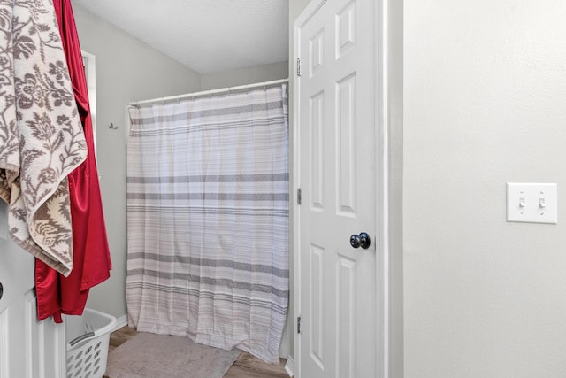 1207 Jefferyscot Dr, Crestview, FL 32536 - bathroom with curtained shower, a textured ceiling, and wood finished floors