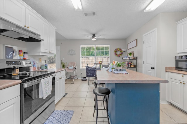 1207 Jefferyscot Dr, Crestview, FL 32536 - kitchen with under cabinet range hood, ceiling fan, stainless steel range with electric cooktop, visible vents, and white cabinets