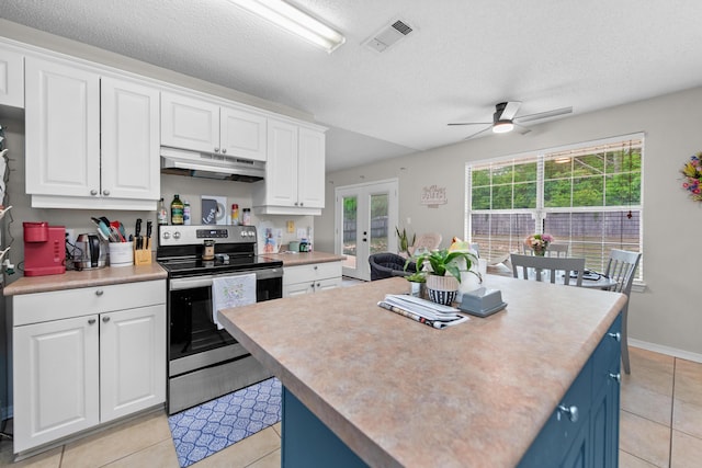 1207 Jefferyscot Dr, Crestview, FL 32536 - kitchen featuring under cabinet range hood, ceiling fan, visible vents, stainless steel range with electric stovetop, and light tile patterned flooring