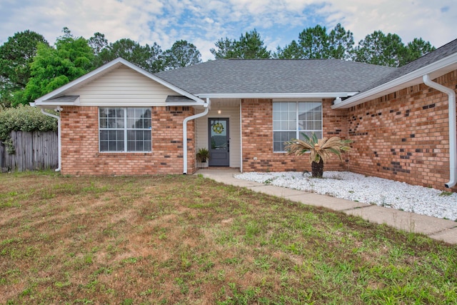 1207 Jefferyscot Dr, Crestview, FL 32536 - ranch-style house with a front yard, fence, a shingled roof, and brick siding