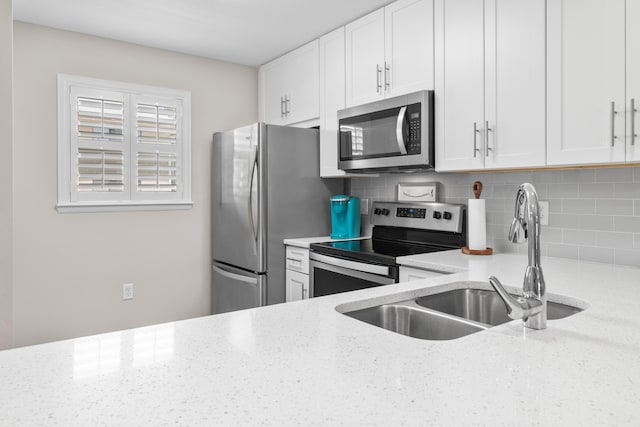 51 Cross Creek Rd Unit 15, Miramar Beach, FL 32550 - kitchen featuring white cabinetry, light stone counters, appliances with stainless steel finishes, and a sink