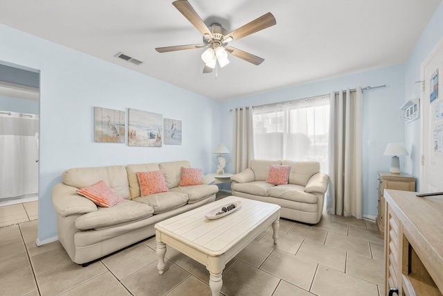 living area featuring light tile patterned floors, visible vents, and ceiling fan