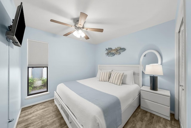 bedroom featuring a ceiling fan, wood finished floors, and baseboards