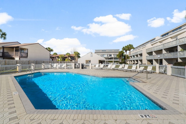 community pool with fence and a patio