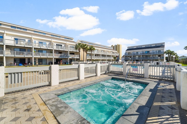 community pool with a hot tub