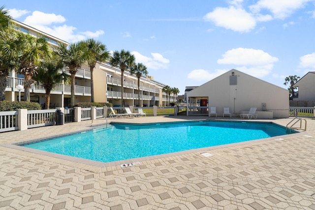 community pool featuring a patio area and fence