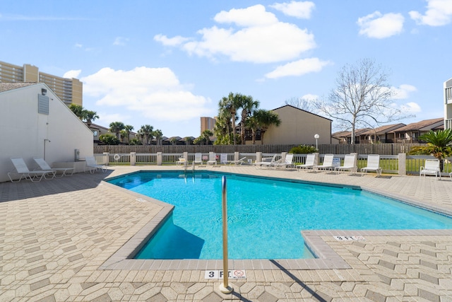 pool with a patio area and fence
