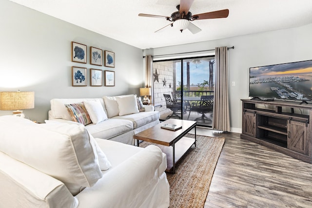 living area with wood finished floors, a ceiling fan, and baseboards