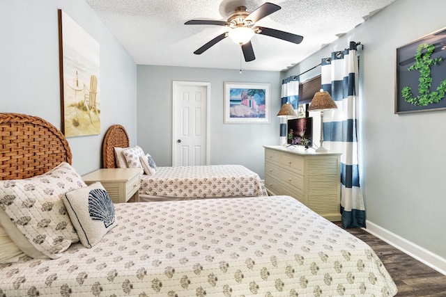 bedroom featuring dark wood-style floors, a textured ceiling, ceiling fan, and baseboards