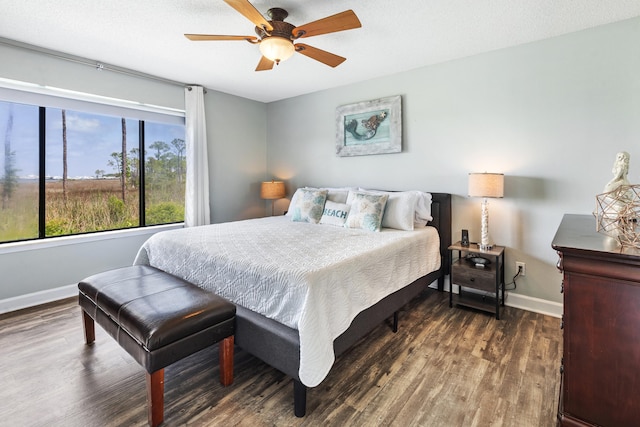 bedroom with ceiling fan, wood finished floors, and baseboards