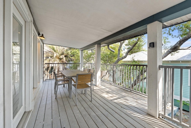 wooden terrace with outdoor dining area and a water view
