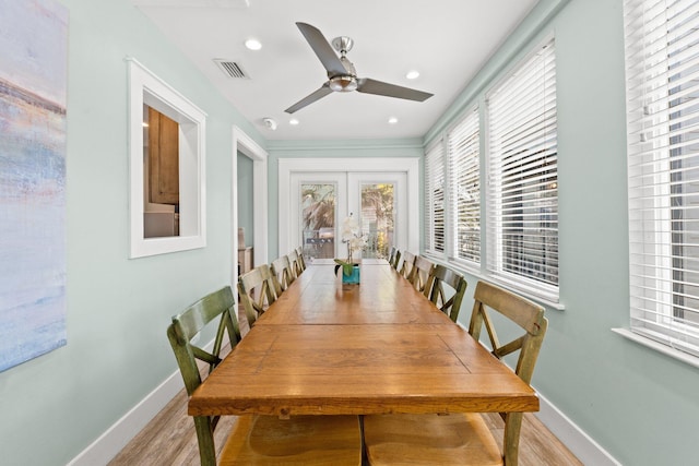 dining area featuring light wood-style floors, ceiling fan, visible vents, baseboards, and french doors