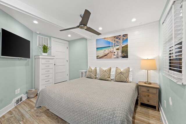 bedroom with baseboards, visible vents, wood finished floors, and a ceiling fan
