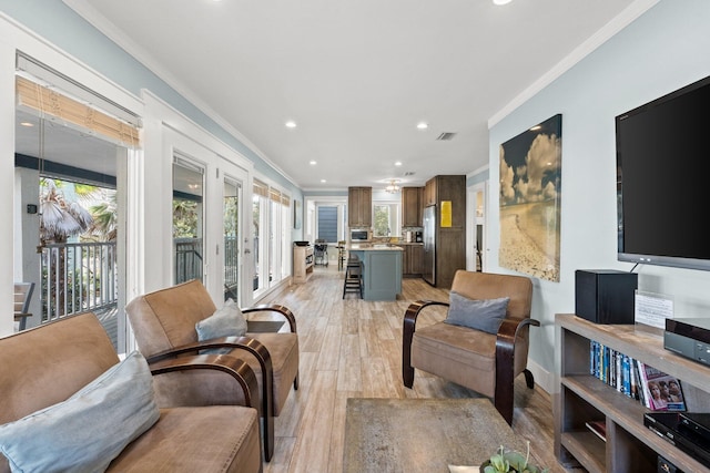 living area featuring ornamental molding, recessed lighting, light wood finished floors, and visible vents