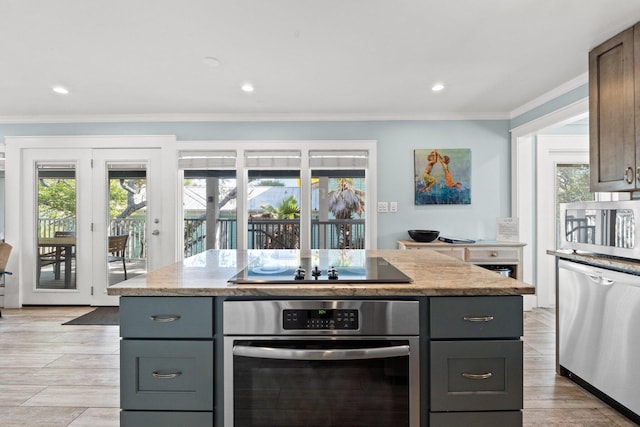 kitchen featuring appliances with stainless steel finishes, light stone countertops, ornamental molding, recessed lighting, and gray cabinets