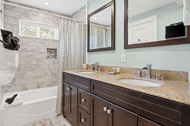 full bath featuring double vanity, shower / bath combo, wood finished floors, and a sink