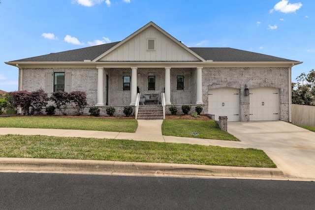 view of front facade with a porch, a garage, a front yard, and brick siding