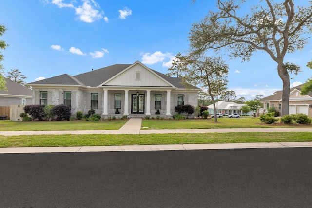 greek revival inspired property with a front lawn, fence, and covered porch