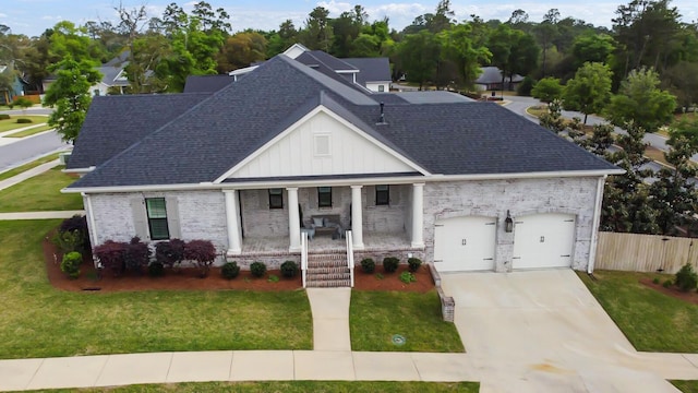 view of front of property featuring covered porch, an attached garage, concrete driveway, and brick siding