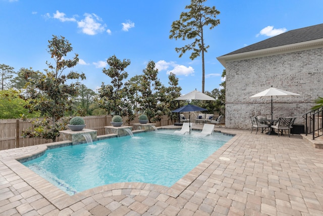 view of swimming pool with a patio, a fenced in pool, a fenced backyard, and outdoor dining space
