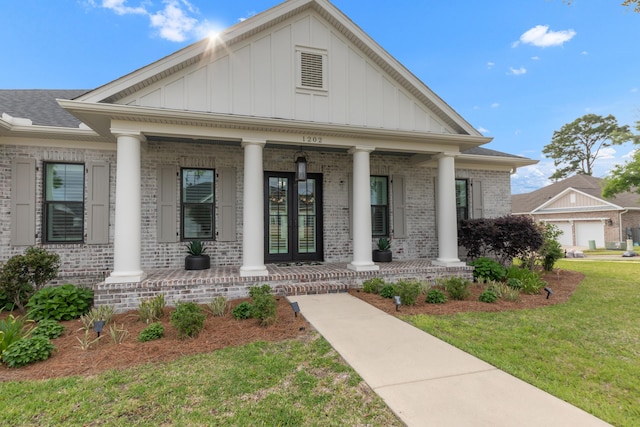 neoclassical home with board and batten siding, a porch, a front lawn, and brick siding