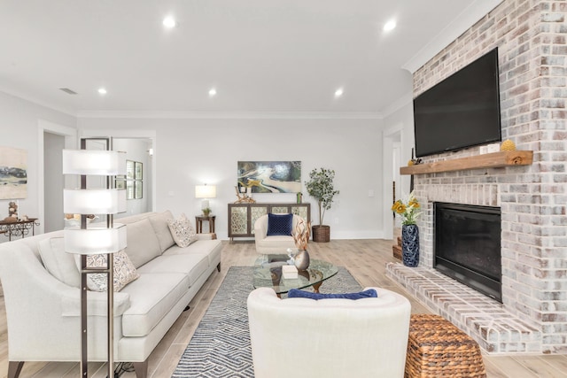 living area featuring light wood-style floors, a brick fireplace, recessed lighting, visible vents, and ornamental molding