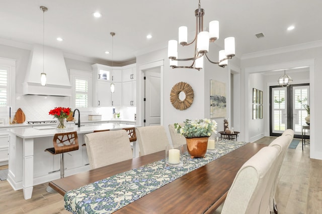 dining area with visible vents, crown molding, an inviting chandelier, recessed lighting, and light wood finished floors