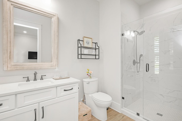 bathroom with vanity, toilet, a marble finish shower, and wood finished floors