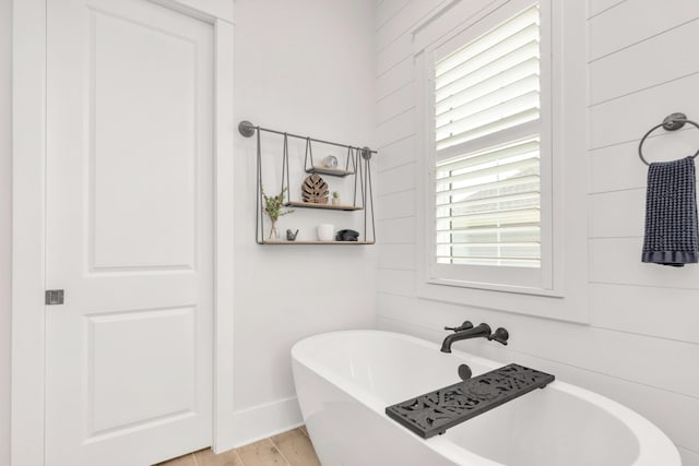 bathroom featuring a freestanding tub and wood finished floors