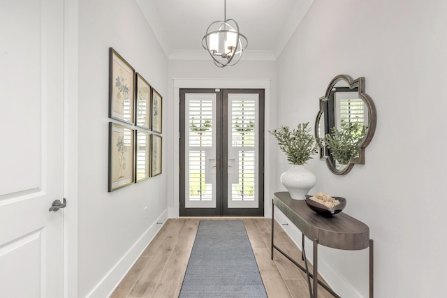 doorway to outside featuring light wood-style floors, french doors, crown molding, baseboards, and an inviting chandelier