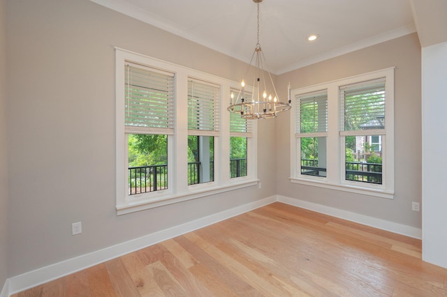 unfurnished dining area with crown molding, baseboards, a chandelier, and wood finished floors