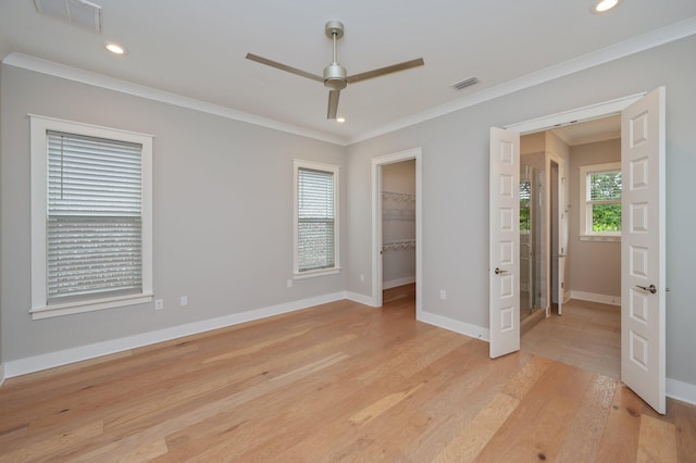 unfurnished bedroom with baseboards, ornamental molding, light wood-type flooring, and visible vents