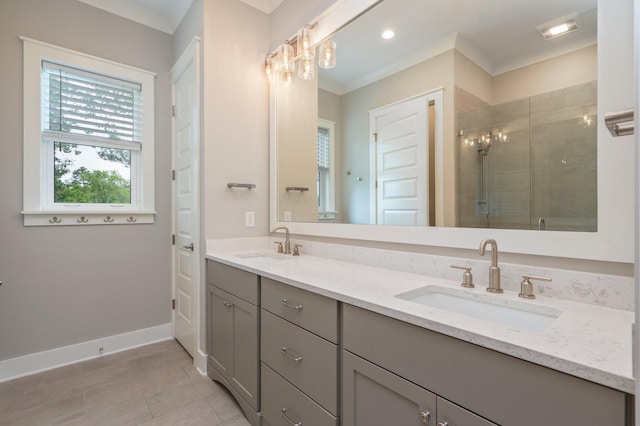 full bathroom with double vanity, a sink, baseboards, and a shower stall