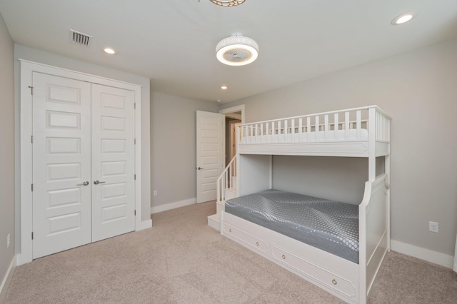 bedroom with carpet floors, recessed lighting, baseboards, visible vents, and a closet