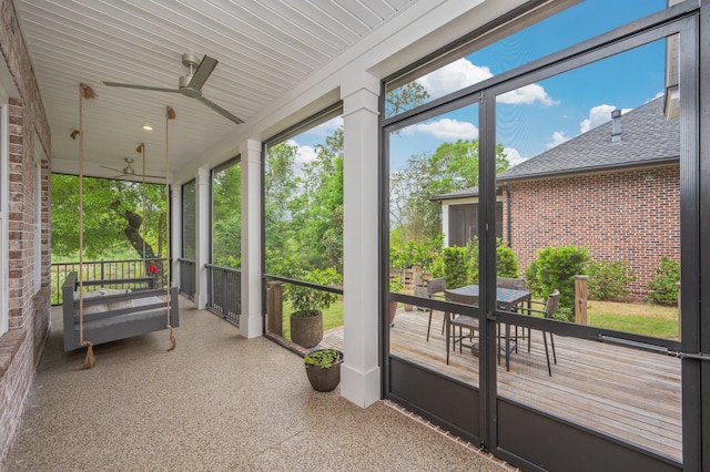unfurnished sunroom with ceiling fan and outdoor dining area
