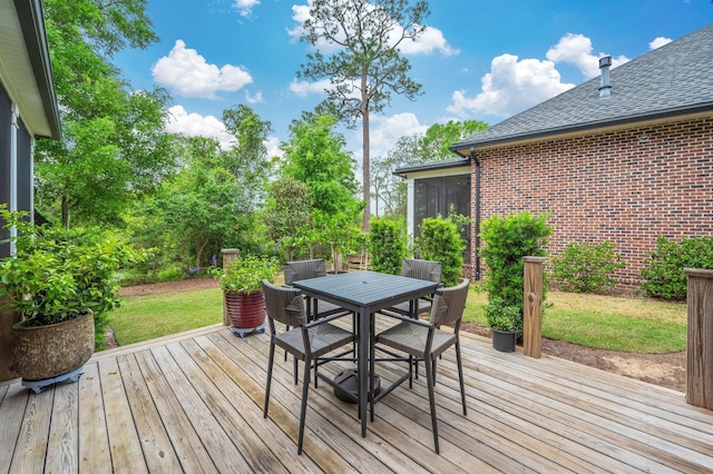 deck featuring outdoor dining area and a yard