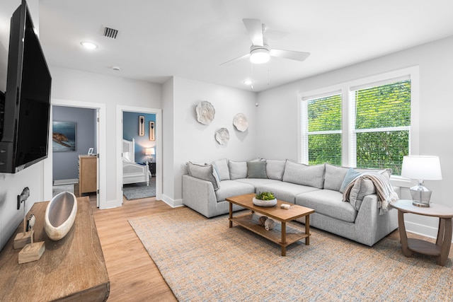 living room featuring ceiling fan, light wood-type flooring, baseboards, and recessed lighting