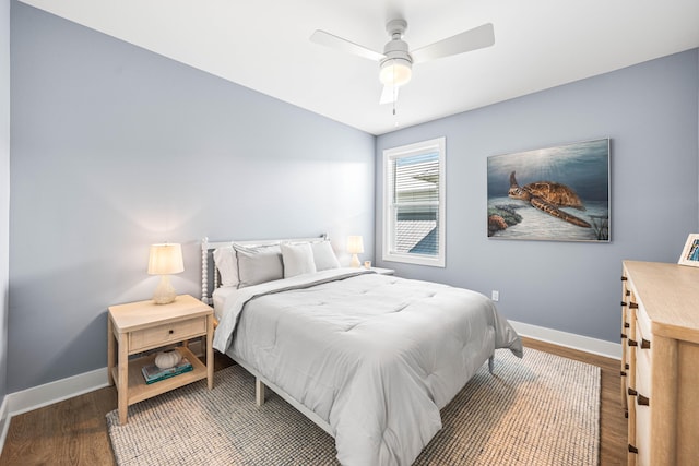 bedroom with wood finished floors, lofted ceiling, baseboards, and ceiling fan