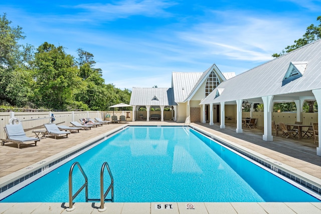 community pool featuring fence, a patio, and a gazebo