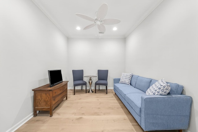 living room with baseboards, ceiling fan, ornamental molding, and light wood-type flooring