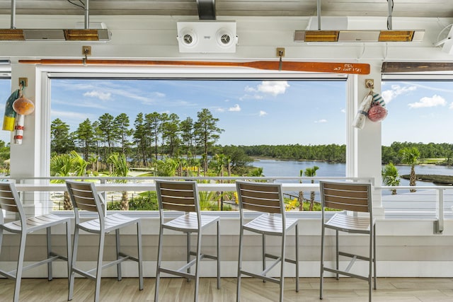 sunroom / solarium featuring a water view