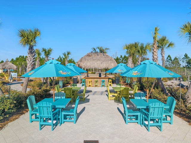 view of patio with fence, outdoor dry bar, and outdoor dining space