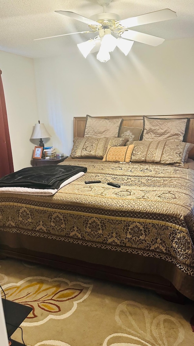bedroom featuring a ceiling fan and a textured ceiling